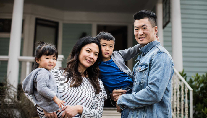 Family standing together outside their home.