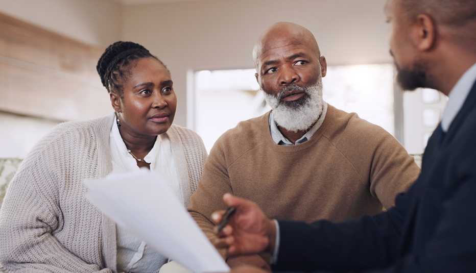 Couple meeting with an advisor reviewing documents.