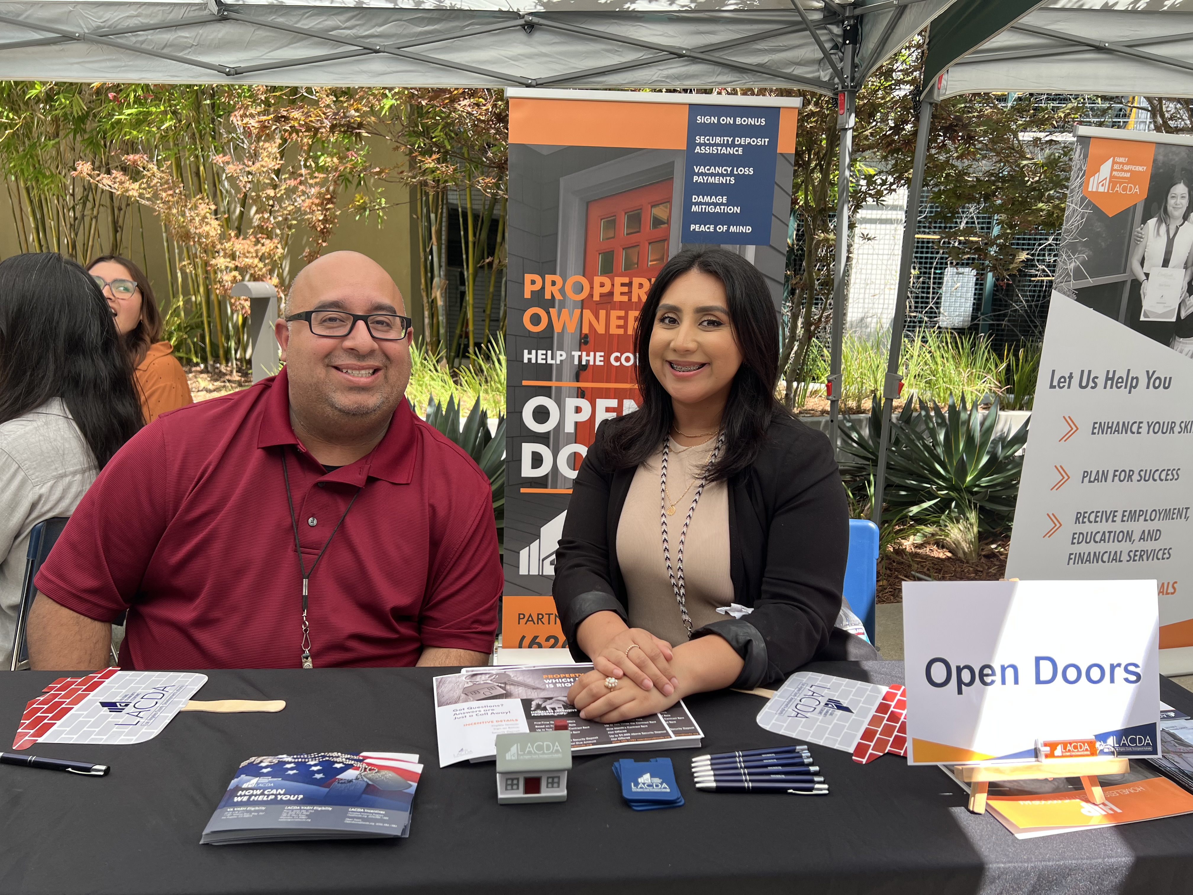 Staff seated at Open Doors Program information booth.