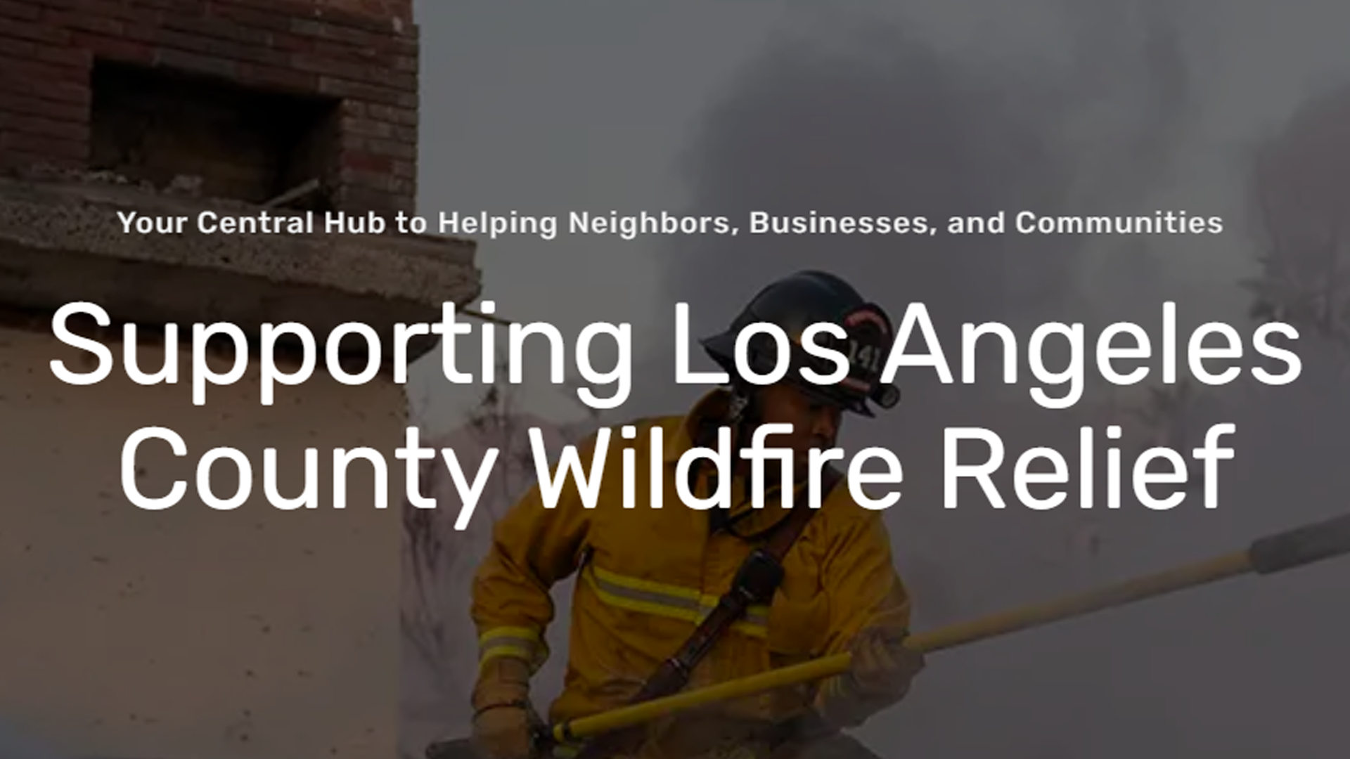 Firefighter spraying water while battling a wildfire in Los Angeles County